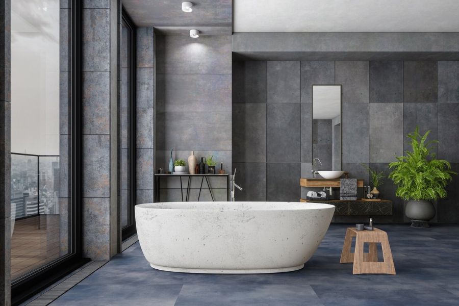 Baño moderno con bañera exenta, revestimiento gris y mueble de lavabo de madera